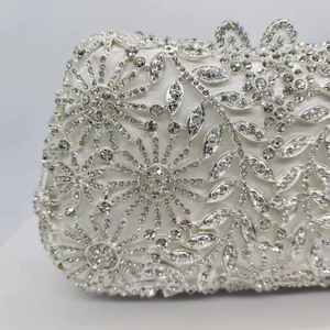 Vue macro de la pochette de luxe argentée avec strass et motif floral ajouré