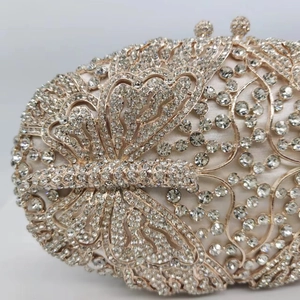Macro detail of champagne crystal butterfly clutch showing intricate hollowed-out metalwork