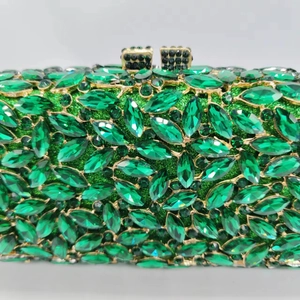 Vue macro des cristaux marquise verts et strass sur une pochette de luxe en métal