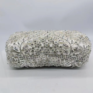 Détails de la pochette de soirée argentée avec strass et motifs floraux ajourés