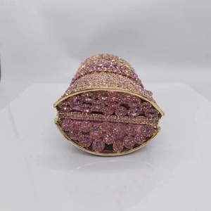 Détail d'une pochette de soirée en cristal rose avec cadre doré et strass brillants