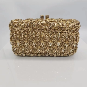 Macro detail of gold floral hollow metal clutch with sparkling champagne crystals