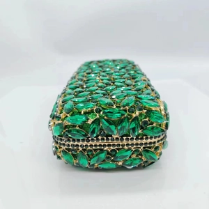 Détail de cristaux vert émeraude et tissu scintillant sur pochette de luxe