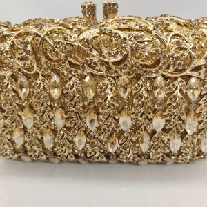 Close-up of hollow metal evening bag with champagne gold plating and crystal inlay