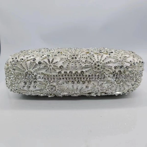 Détail d'une pochette en strass argentés avec des motifs floraux en cristal