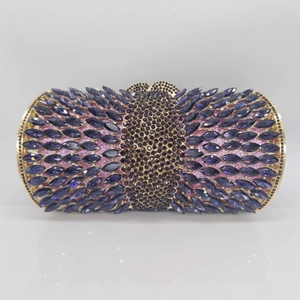 Detailed view of hollow metal evening clutch with purple crystals and gold frame