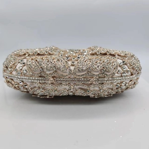 Macro view of crystal encrusted butterfly evening bag with gold floral hollow framework