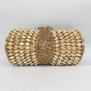 Close-up of champagne gold clutch bag with marquise and round crystals decoration