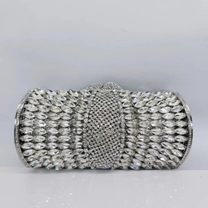 Detailed macro shot of silver hollow-out clutch with brilliant crystals and gem-style clasp