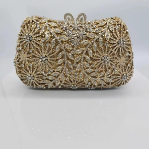 Vue détaillée d'une pochette dorée ornée de strass étincelants et de motifs floraux