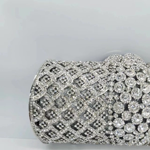 Gros plan sur pochette de soirée argentée avec maillage cristal et détails de fleurs strass