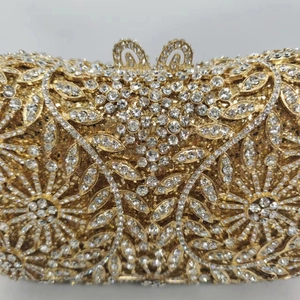 Détail d'une pochette dorée ajourée avec strass et motifs floraux en cristal de luxe