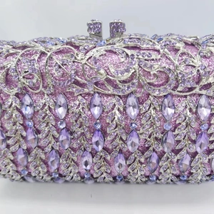 Close-up of hollow floral silver metal frame with purple marquise crystals on clutch