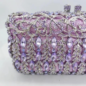Detail of purple crystal clutch bag with silver hollowed metal leaf patterns