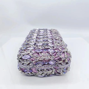 Close-up of purple rhinestones and silver metal leaf patterns on luxury evening clutch