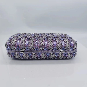 Detailed view of purple crystals and silver floral hollow metal on the clutch bag