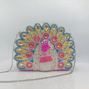 Detailed macro view of peacock clutch bag with colorful rhinestones and silver chain strap