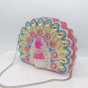 Detail of pink crystal peacock clutch with colorful gemstones and silver chain
