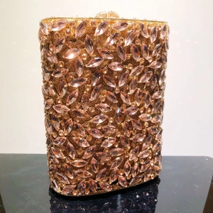 Makro-Detail der rosa Marquise-Strasssteine und des Goldrahmens an einer Abend-Clutch