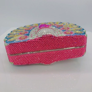 Detailed close-up of a luxury pink peacock crystal clutch with intricate rhinestone patterns