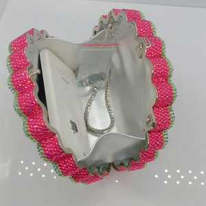 Pink rhinestone fan-shaped clutch interior showing capacity with phone and chain strap