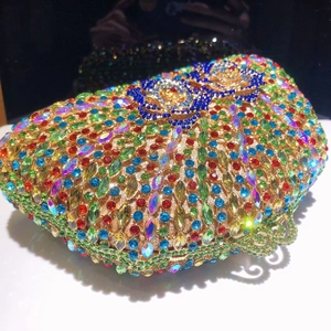 Macro shot of colorful rhinestone evening bag with intricate gold floral hollow metal clasp
