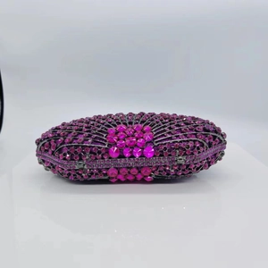 Detail of fan-shaped evening clutch with pink rhinestones and a large center gemstone