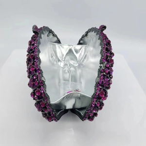 Close-up of luxury fuchsia rhinestone evening clutch bag with metallic silver lining