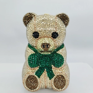 Close-up of luxury teddy bear clutch with gold crystals and a green clover charm