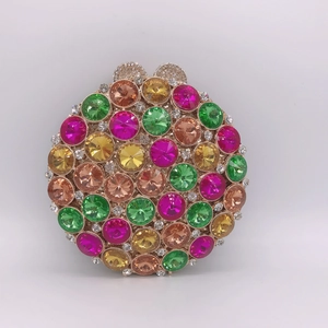 Détails de la pochette de soirée ronde ornée de strass colorés et cadre doré luxueux