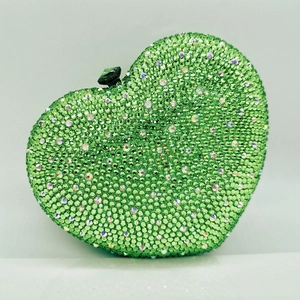 Close-up of heart-shaped evening bag with green rhinestones and jewel clasp