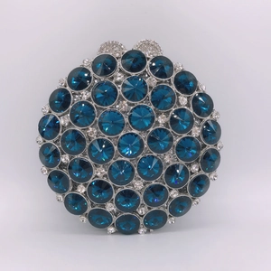 Gros plan des cristaux bleu foncé et du cadre argenté sur ce sac à main rond
