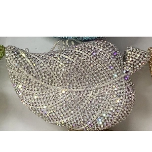 Close-up of sparkling leaf-shaped crystal clutch with detailed metal vein patterns