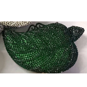 Detailed view of leaf-shaped evening clutch with dark green rhinestones and metal leaf veins