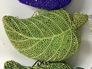 Macro view of crystal encrusted leaf-shaped clutch bag showing intricate green rhinestones