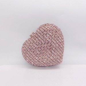 Close-up of luxury heart-shaped evening clutch bag with light pink rhinestone crystals