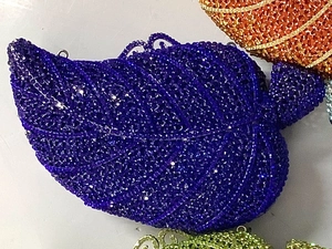 Detailed close-up of dark purple crystal-encrusted leaf-shaped evening clutch bag