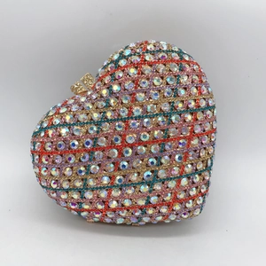Macro shot of colorful rhinestone heart clutch bag with metallic frame and push buckle