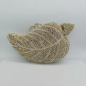 Detailed close-up of leaf-shaped crystal clutch bag featuring intricate metal hollow patterns