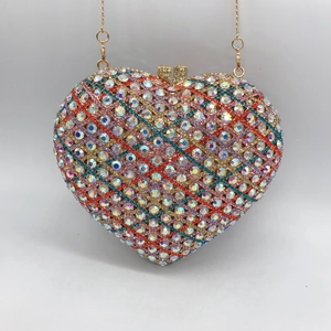 Macro shot of heart-shaped clutch bag featuring colorful rhinestones and gold clasp