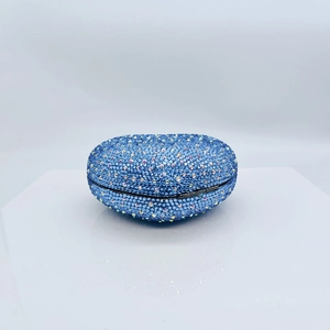 Detailed close-up of blue heart-shaped evening clutch bag with sparkling rhinestones