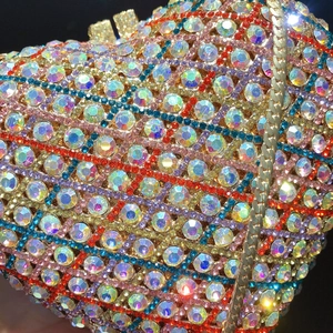 Macro detail of luxury heart-shaped clutch bag with multi-color rhinestones and gold chain