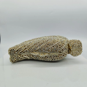 Macro view of crystal leaf clutch showing intricate gold metal frame and rhinestones