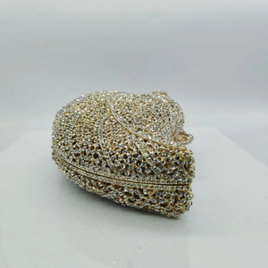 Detail of leaf pattern and crystal-encrusted surface on golden heart clutch bag