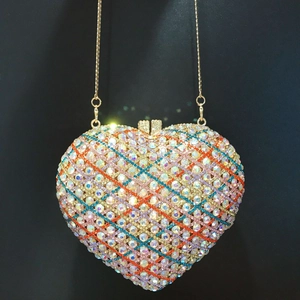 Close-up of heart-shaped clutch bag featuring multi-color rhinestones and gold chain
