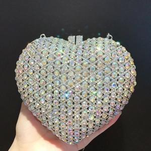 Macro view of heart-shaped luxury clutch bag with iridescent rhinestones and silver metal frame