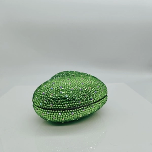 Detail shot of heart-shaped clutch bag with luxury green rhinestones on metal frame