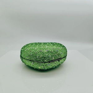 Close-up of emerald green heart evening bag with sparkling rhinestones and metal clasp