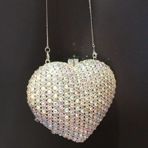 Detailed macro view of heart shaped clutch bag with colorful rhinestones and silver chain