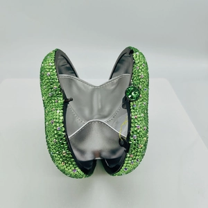 Macro shot of green rhinestone evening clutch showing the silver interior and gem clasp